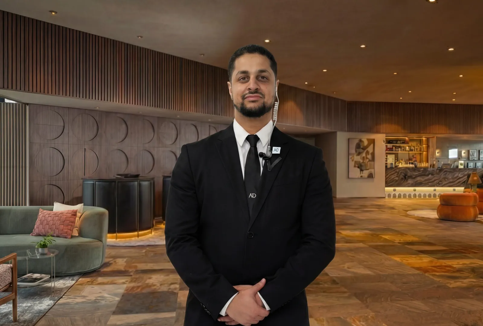 Beveiliger van All Day Services in pak met oortje verzorgt discrete persoonsbeveiliging in een lobby